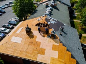Two adjacent houses, one with a sloped shingle roof and the other with a flat membrane roof, seen in a suburban neighborhood.